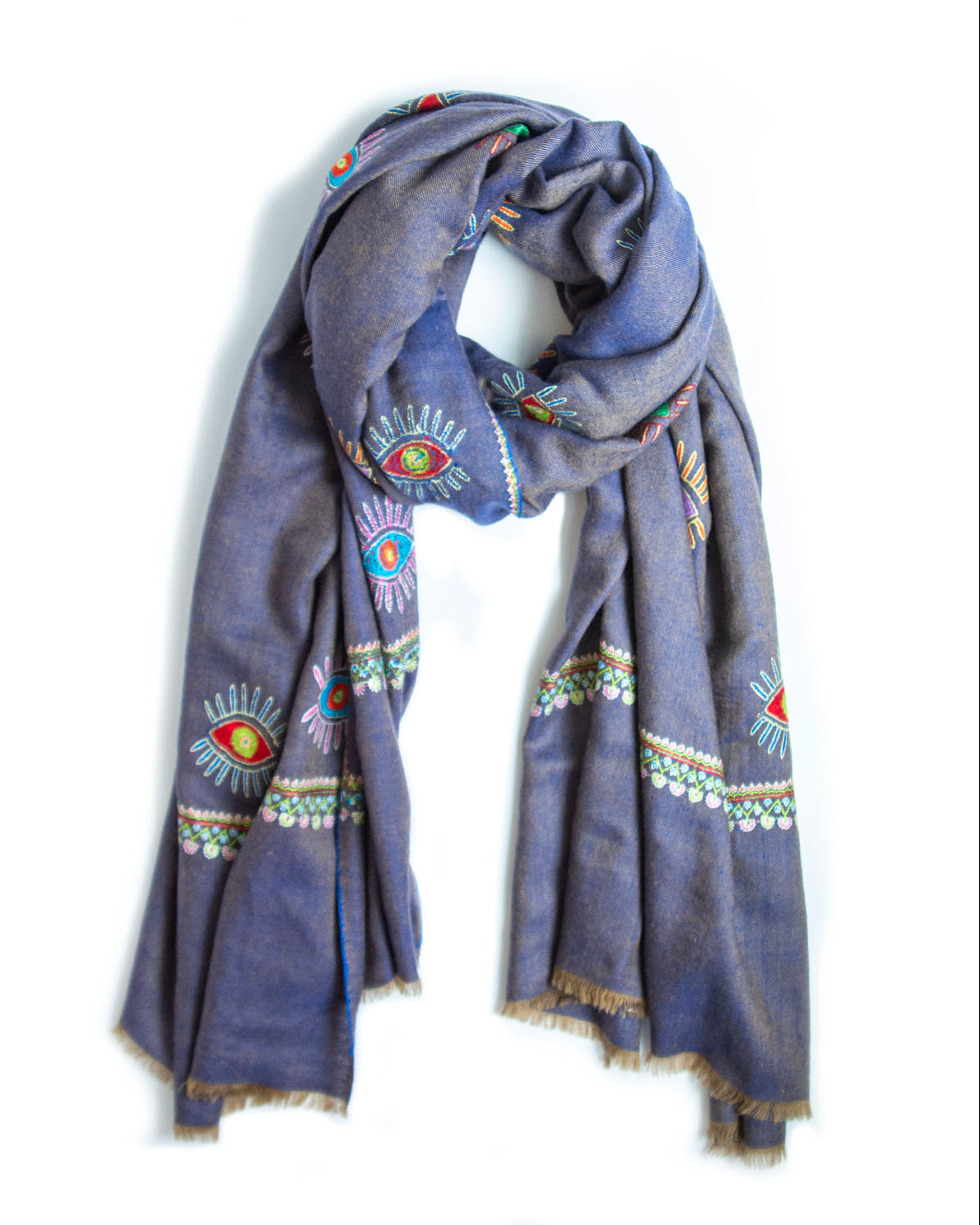 A slate blue scarf with colorful embroidered eye and geometric patterns, featuring fringed edges, displayed on a white background.