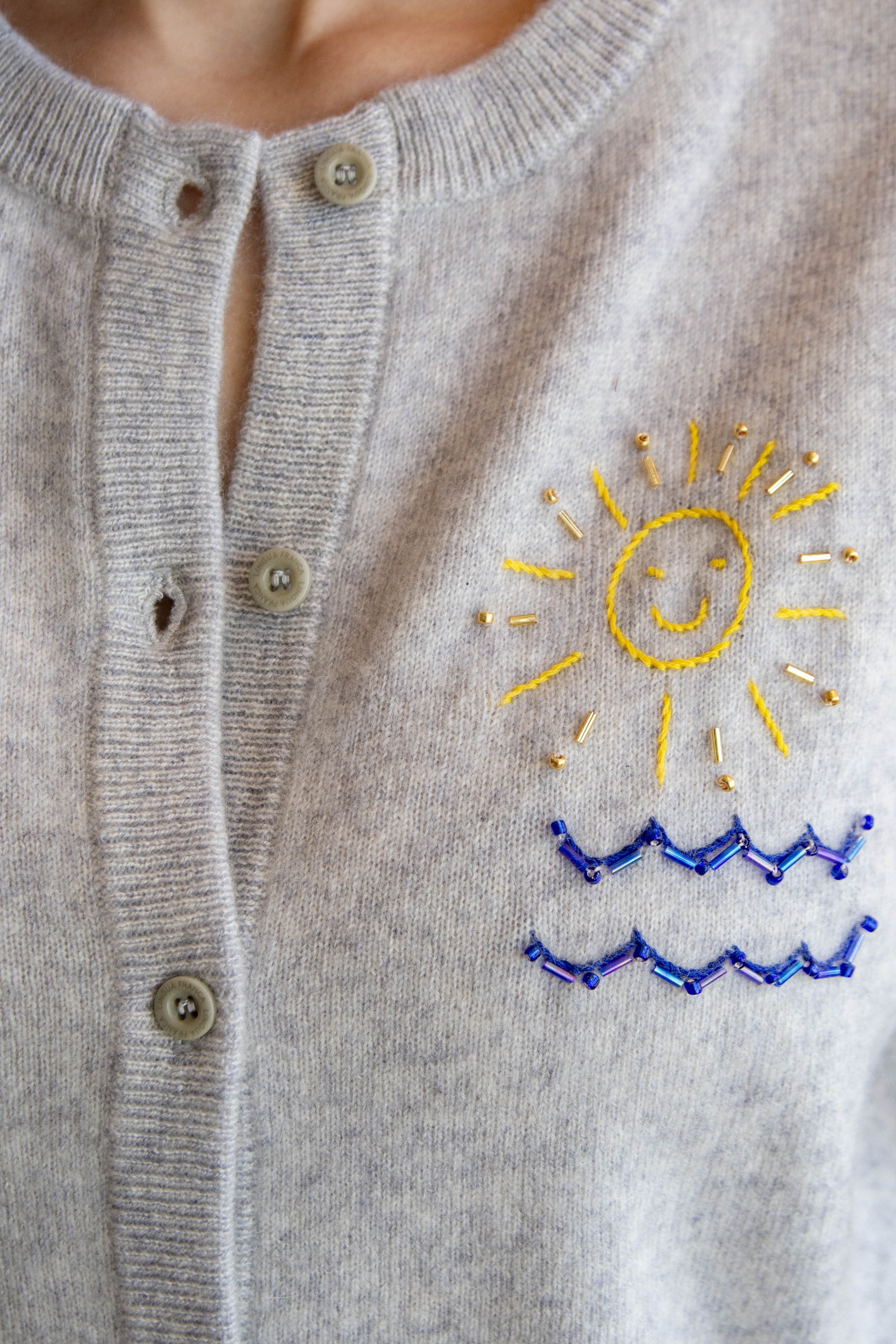 Gray cardigan with embroidered sun and wave design
