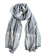 A gray scarf with delicate multicolor embroidered patterns and fringed edges, draped on a plain white background.