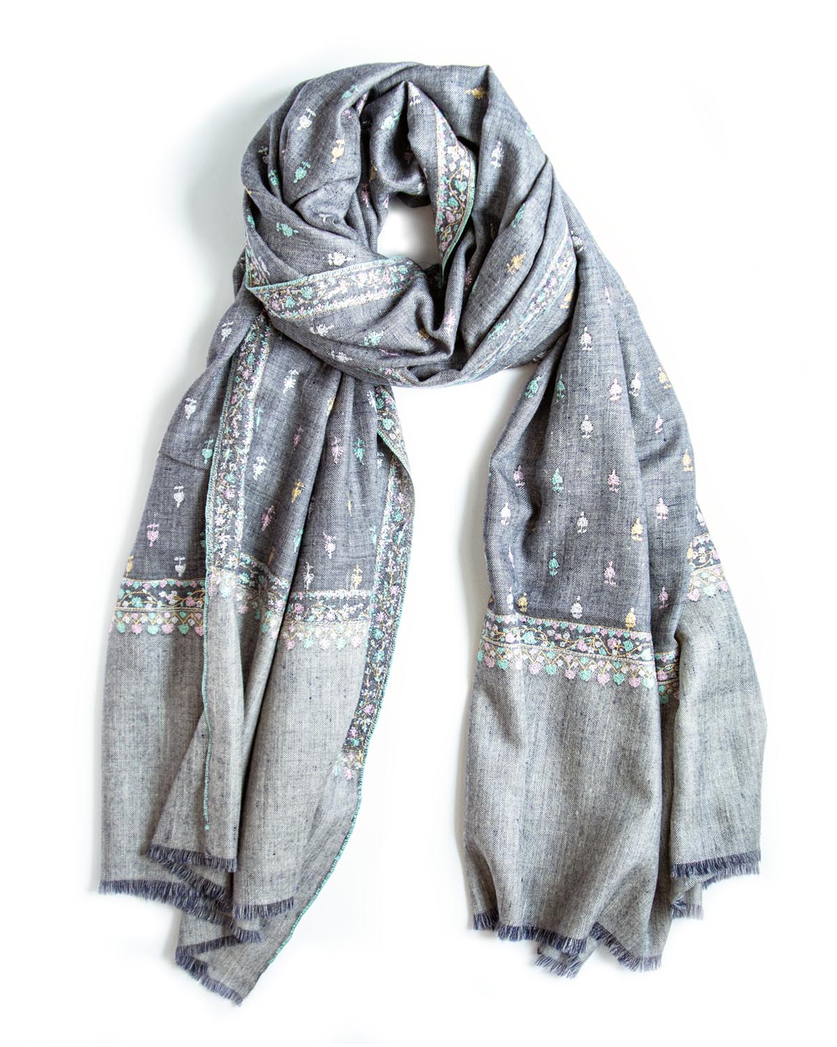 A gray scarf with delicate multicolor embroidered patterns and fringed edges, draped on a plain white background.