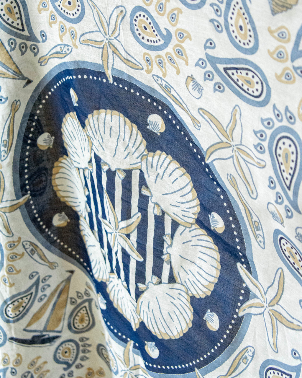 Patterned fabric with seashells and starfish design on a blue background
