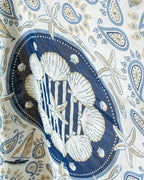 Patterned fabric with seashells and starfish design on a blue background