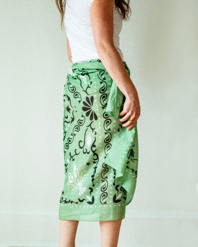 Green patterned skirt worn by a person on a plain background