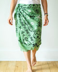Person wearing a green patterned skirt on a white background