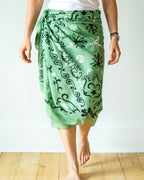 Person wearing a green patterned skirt on a white background